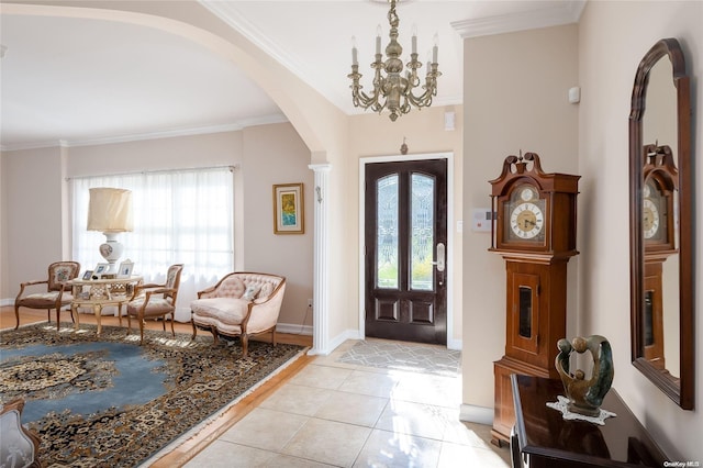 foyer featuring light tile patterned floors, an inviting chandelier, and crown molding