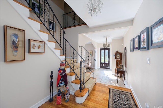 foyer entrance with hardwood / wood-style floors and a notable chandelier