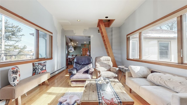 living room featuring a baseboard radiator, plenty of natural light, a chandelier, and light hardwood / wood-style flooring