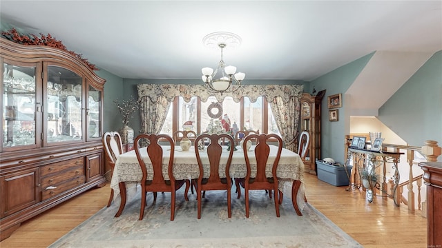 dining area featuring an inviting chandelier and light hardwood / wood-style floors