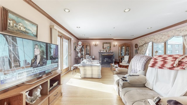 living room featuring crown molding, light wood-type flooring, and a wealth of natural light