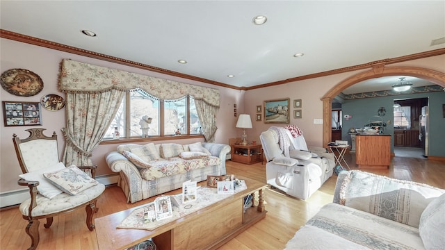 living room with crown molding, a baseboard radiator, and light wood-type flooring