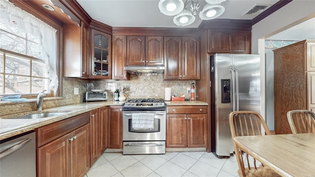 kitchen featuring light tile patterned flooring, sink, tasteful backsplash, appliances with stainless steel finishes, and light stone countertops