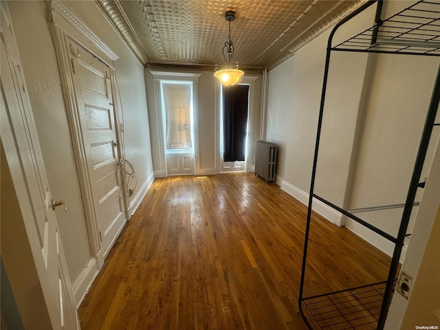 interior space featuring radiator heating unit, ornamental molding, and hardwood / wood-style flooring