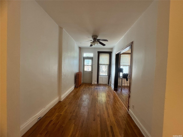 doorway with dark hardwood / wood-style floors, ceiling fan, and radiator heating unit