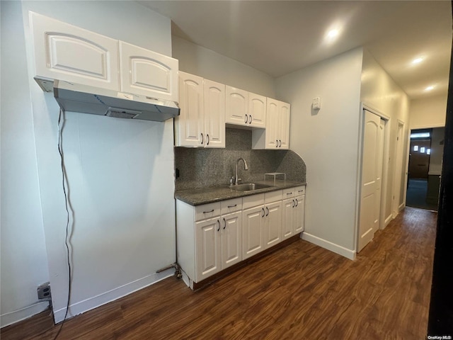 kitchen with dark hardwood / wood-style flooring, backsplash, white cabinetry, and sink