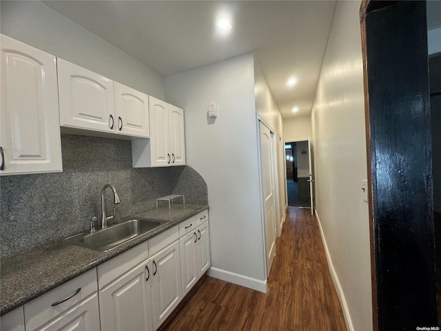 kitchen with decorative backsplash, dark hardwood / wood-style flooring, white cabinetry, and sink