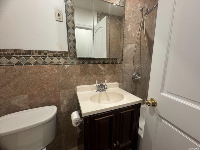 bathroom with vanity, toilet, and tile walls