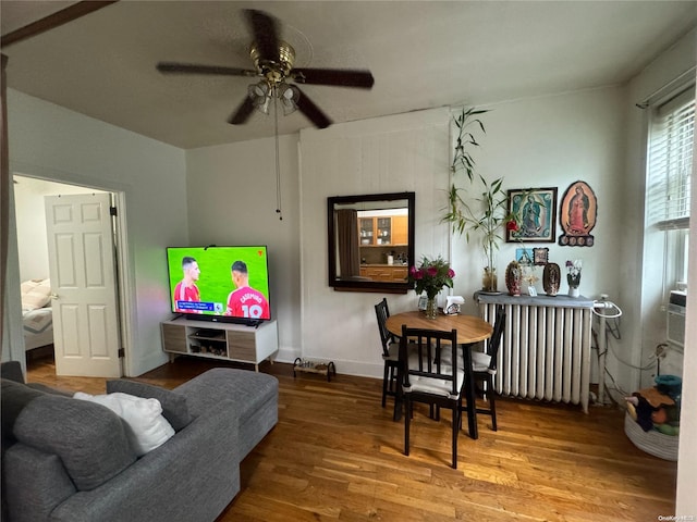 living room with hardwood / wood-style flooring, ceiling fan, and radiator heating unit