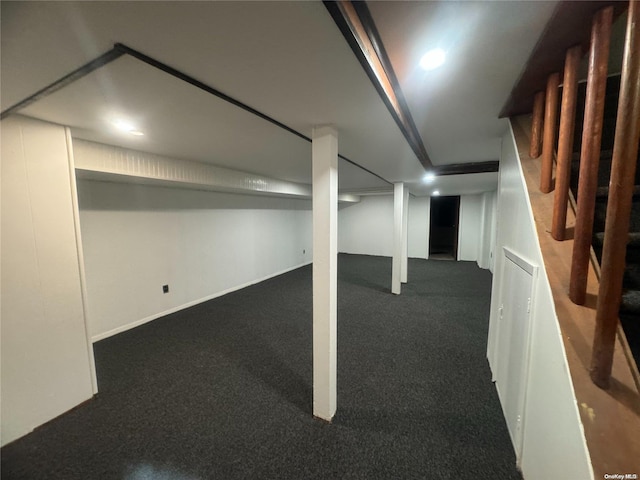 basement featuring dark carpet