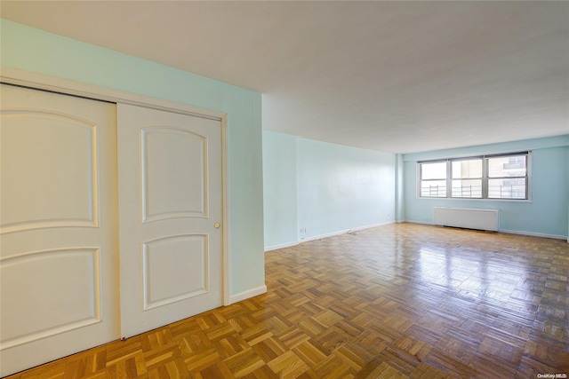 spare room with radiator and parquet flooring