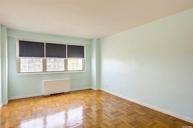 empty room featuring light parquet floors and radiator