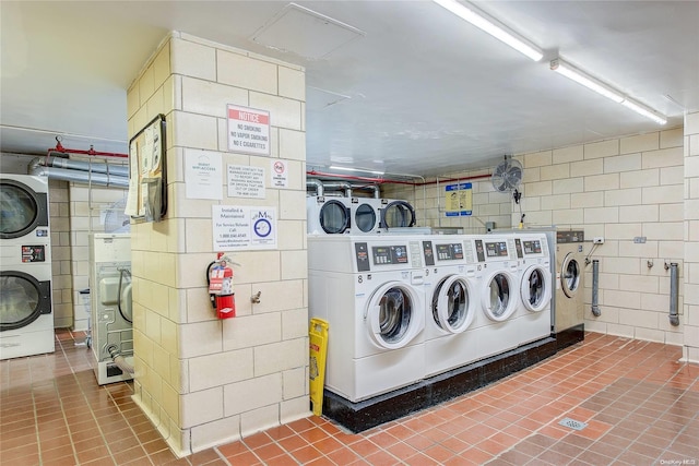 washroom with tile patterned flooring, washer and clothes dryer, tile walls, and stacked washer and clothes dryer