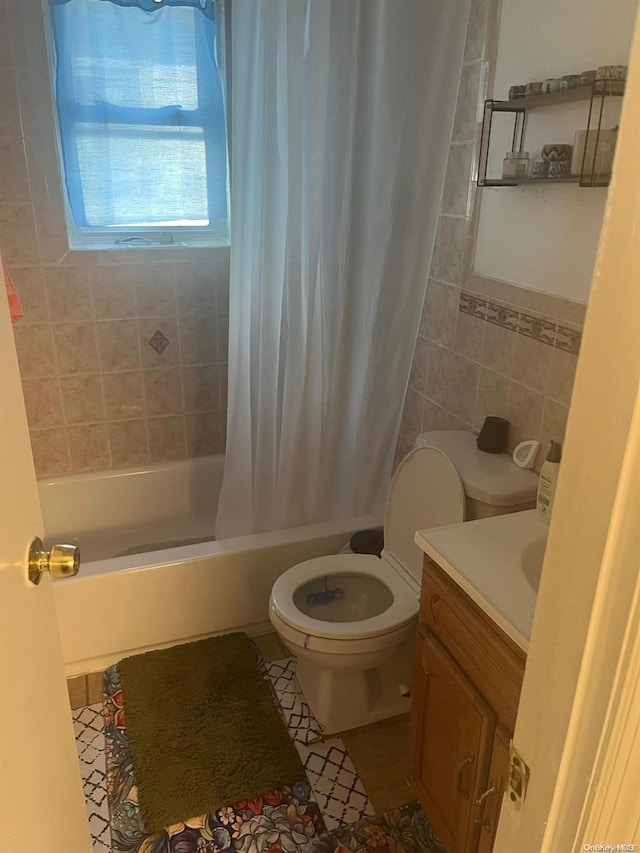 full bathroom with tile patterned flooring, shower / bath combination with curtain, vanity, and tile walls