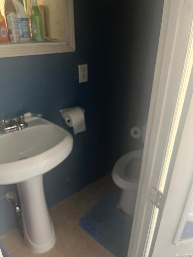 bathroom featuring tile patterned flooring, toilet, and sink