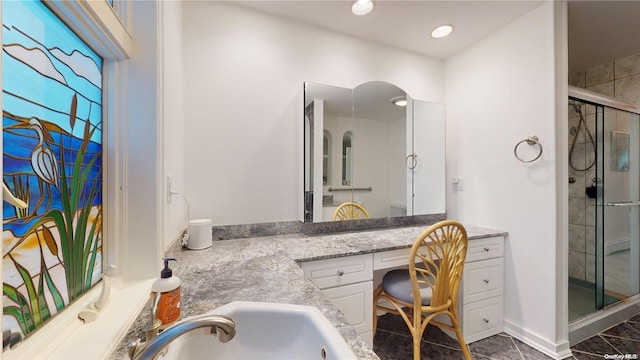 bathroom with vanity and a shower with shower door