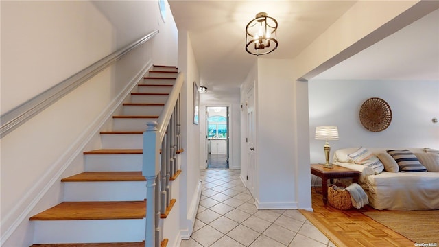 staircase featuring tile patterned flooring and a notable chandelier