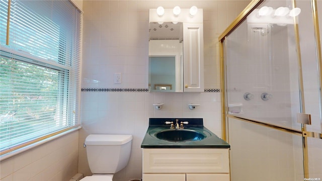 bathroom with tile walls, vanity, an enclosed shower, and toilet