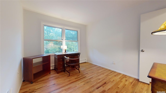 home office with baseboard heating and light hardwood / wood-style floors