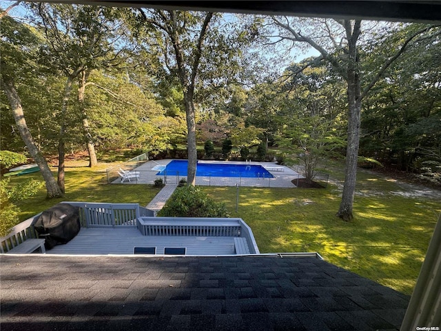 view of pool featuring a deck and a lawn