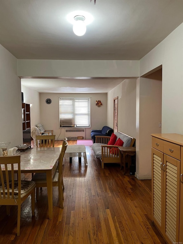 dining area featuring dark wood-type flooring and radiator heating unit