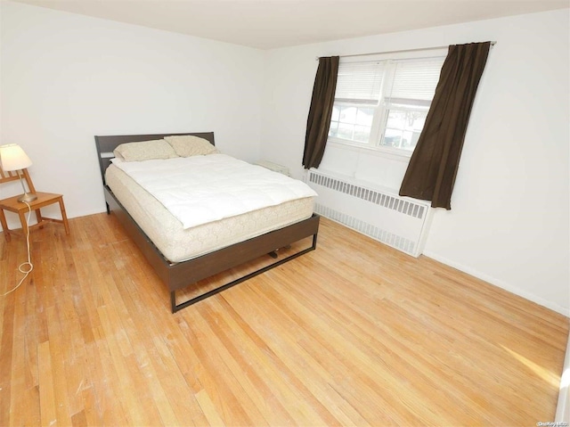 bedroom featuring light wood-type flooring and radiator