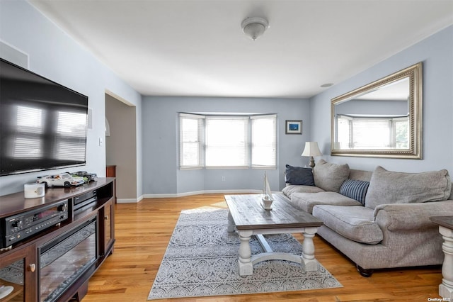 living room with plenty of natural light and light hardwood / wood-style flooring