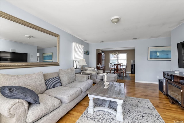 living room with hardwood / wood-style flooring and an inviting chandelier