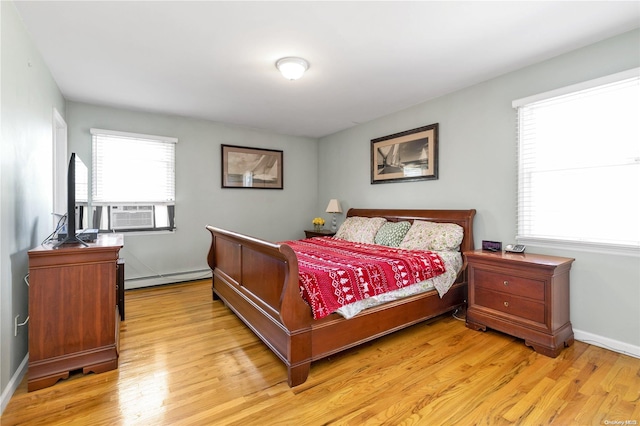 bedroom with cooling unit, light hardwood / wood-style flooring, multiple windows, and a baseboard heating unit