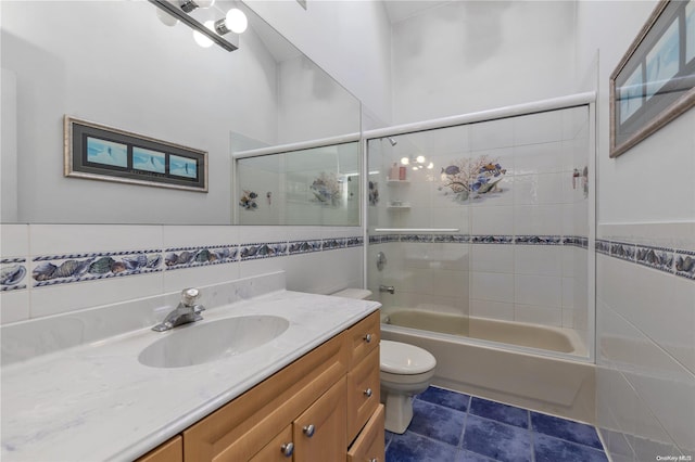 full bathroom featuring toilet, vanity, tile walls, and tiled shower / bath