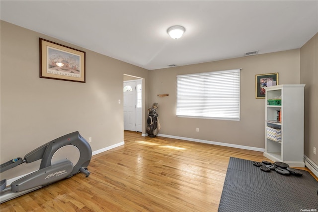 exercise area with light hardwood / wood-style flooring