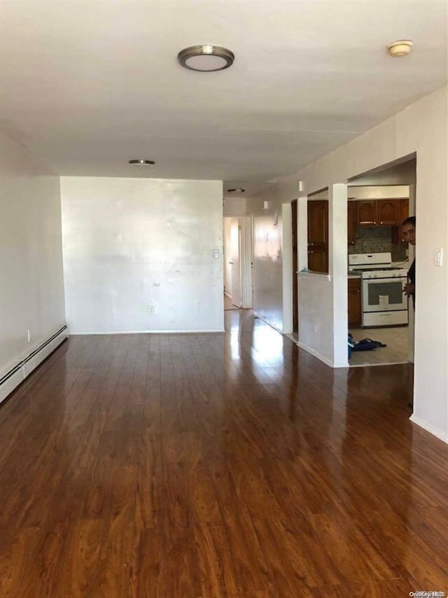 spare room with dark hardwood / wood-style flooring and baseboard heating