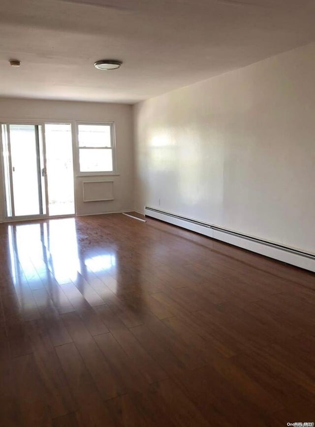 unfurnished room featuring dark wood-type flooring and a baseboard radiator