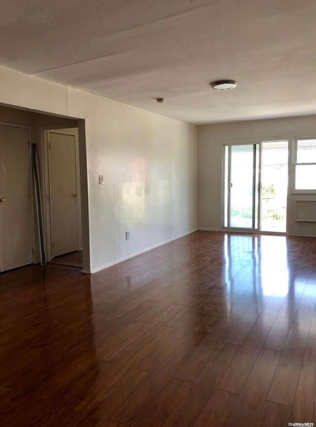 unfurnished room with dark hardwood / wood-style floors