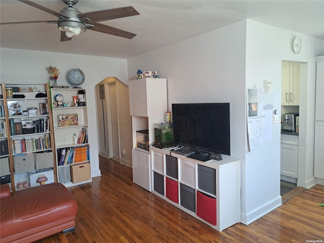 living room featuring ceiling fan and dark wood-type flooring