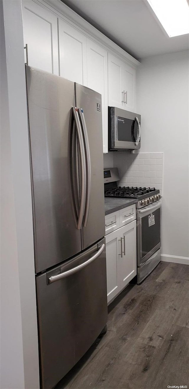 kitchen with backsplash, dark hardwood / wood-style flooring, white cabinets, and stainless steel appliances