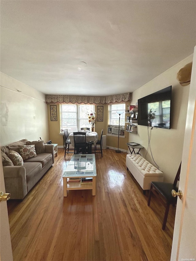 living room with wood-type flooring, a wealth of natural light, and cooling unit