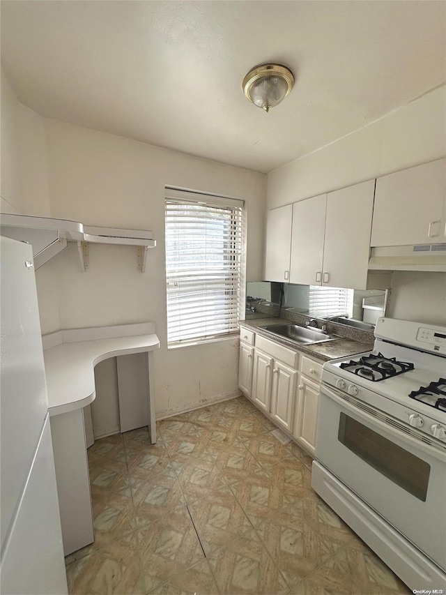 kitchen with white range with gas stovetop, white cabinets, and sink