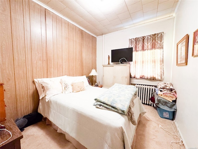 carpeted bedroom with wooden walls, ornamental molding, and radiator