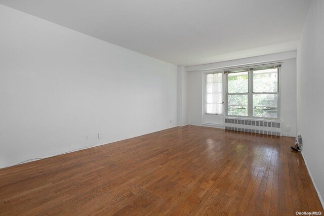 35-51 85th St Unit 3-L, Jackson Heights, NY 11372 - unfurnished room featuring dark hardwood / wood-style floors and radiator heating unit