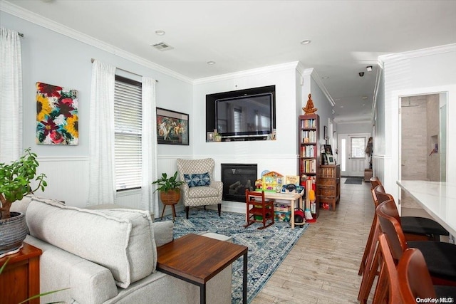 living room with crown molding and light wood-type flooring