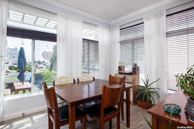 dining space featuring a wealth of natural light, crown molding, and light wood-type flooring