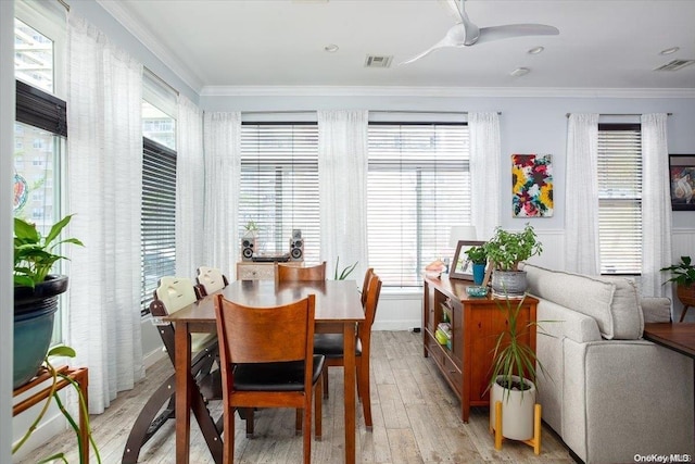 dining space featuring a wealth of natural light, light hardwood / wood-style flooring, ceiling fan, and crown molding