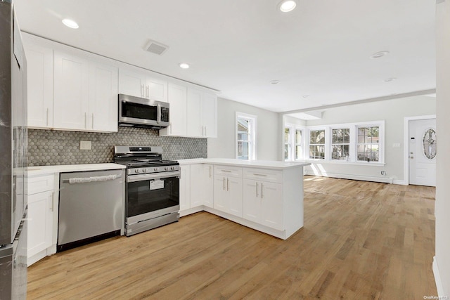 kitchen featuring light hardwood / wood-style flooring, white cabinets, and appliances with stainless steel finishes