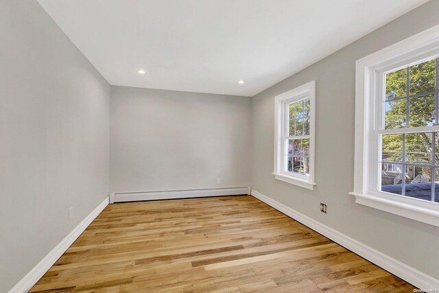 spare room featuring light hardwood / wood-style floors and a baseboard heating unit