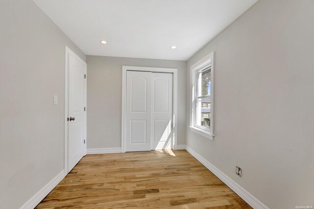 unfurnished bedroom with a closet and light hardwood / wood-style floors