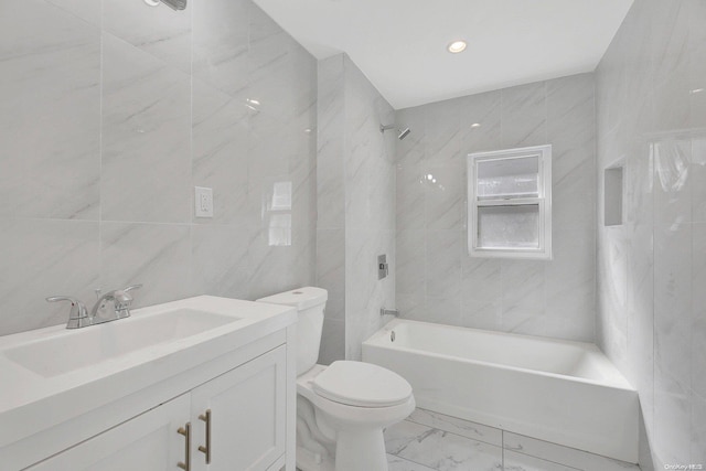 full bathroom featuring vanity, tiled shower / bath combo, toilet, and tile walls