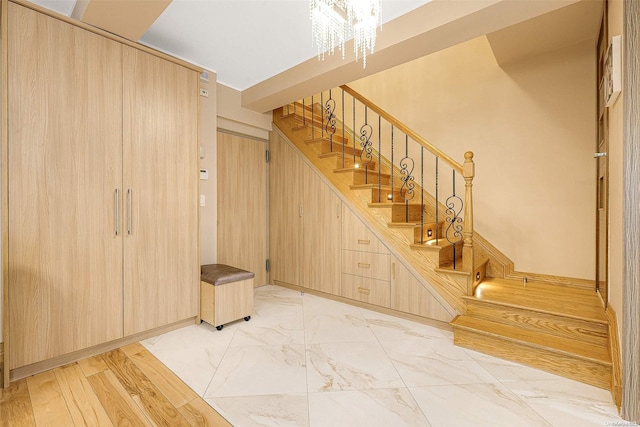 staircase featuring a chandelier and hardwood / wood-style flooring