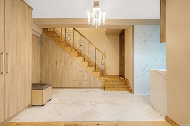 stairs with an inviting chandelier