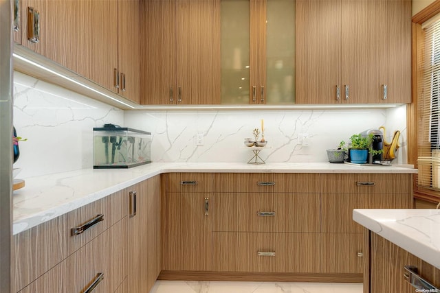 kitchen featuring light stone countertops and backsplash